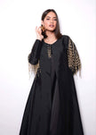 Woman wearing a black dress with gold embellishments on a white background